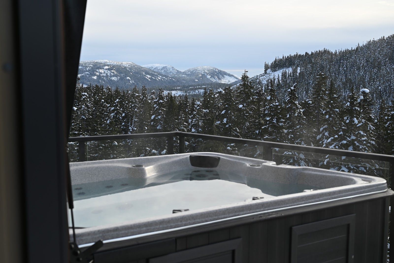 Steaming hot tub overlooking snowy mountains at Mammoth Chalet